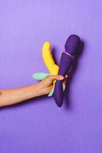 Colorful silicone sex toys against a purple background for sexual wellness and education.